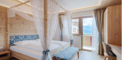 Bedroom with canopy bed and balcony